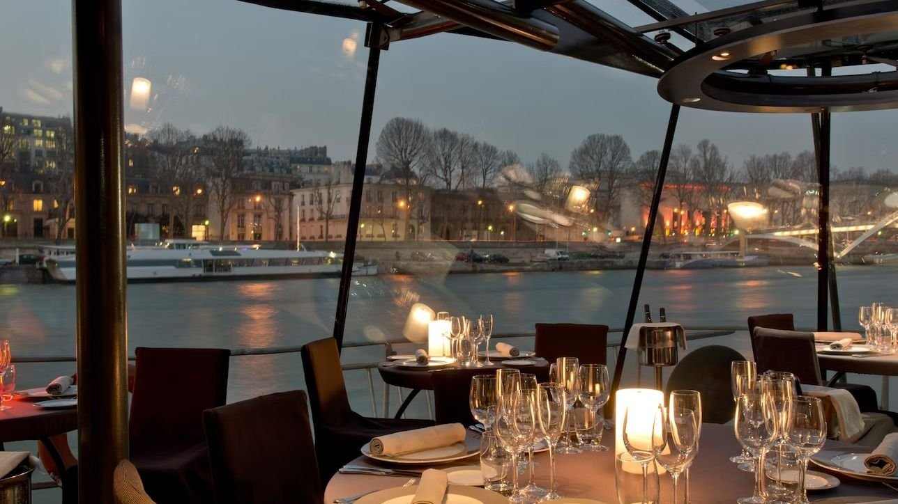 Dining table setup with wine inside the Bateaux Parisiens cruise boat