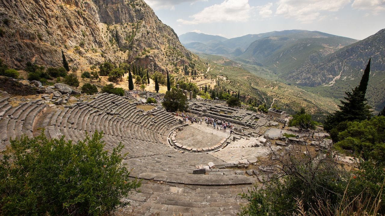 Historic stone ruins of ancient Delphi against mountain scenery