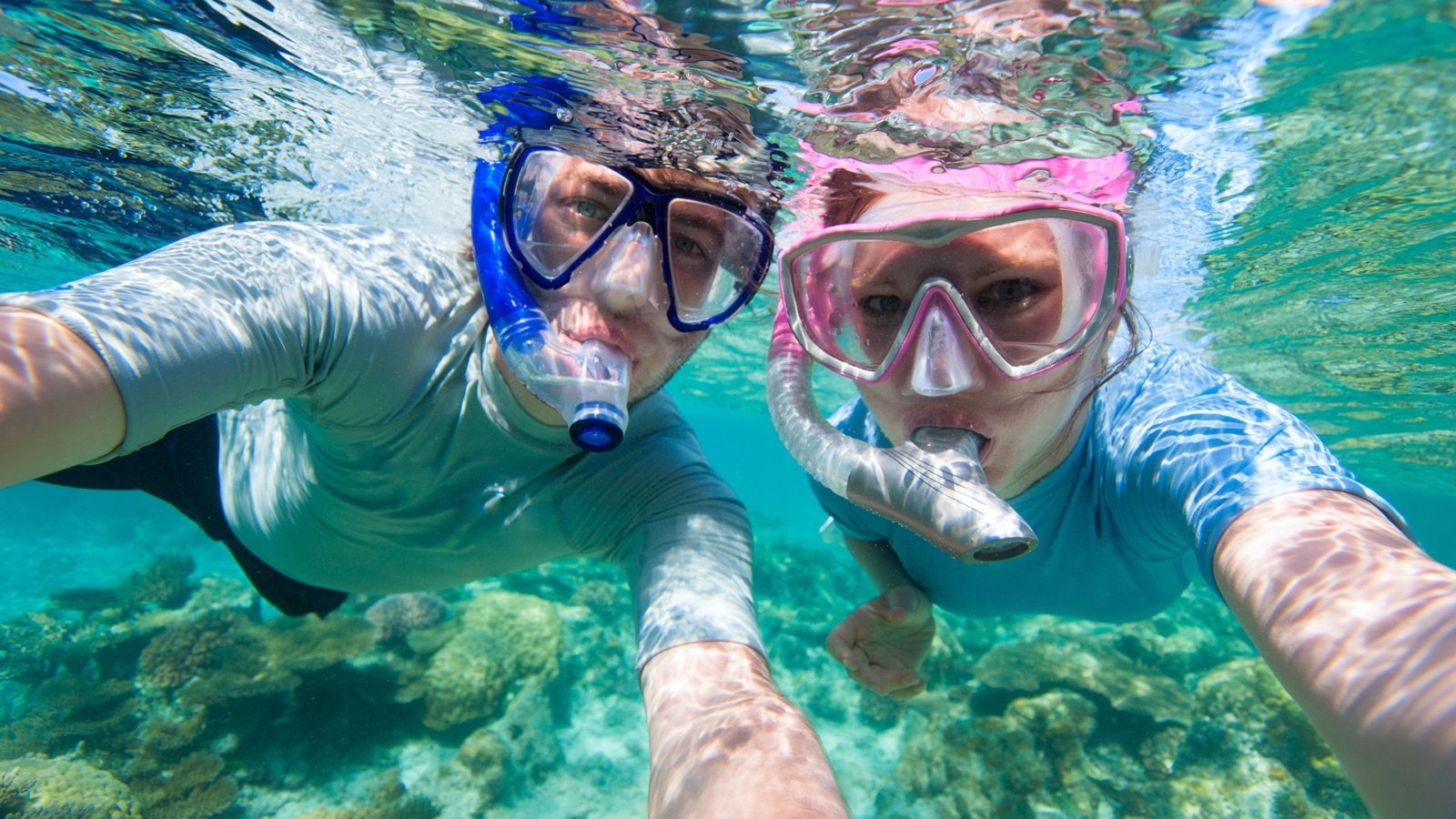 Snorkeling in clear waters with mountain backdrop
