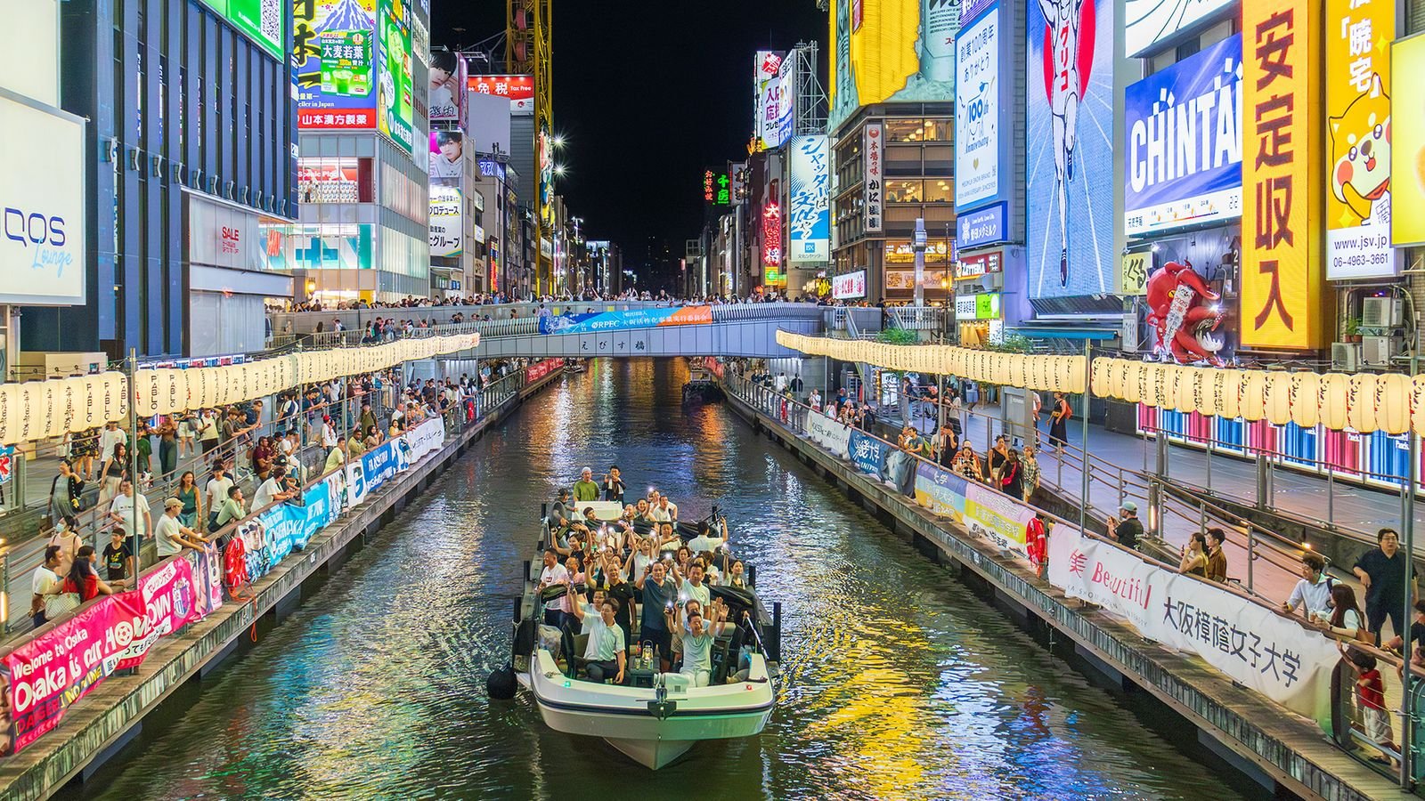 Bustling riverside streets and neon lights along the Dotonbori River in Osaka