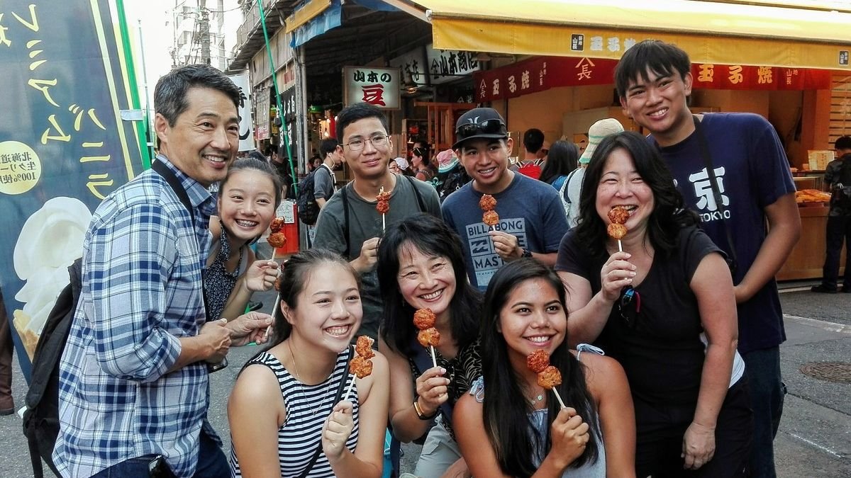 Guide leading visitors through Tsukiji Outer Market stalls in Tokyo