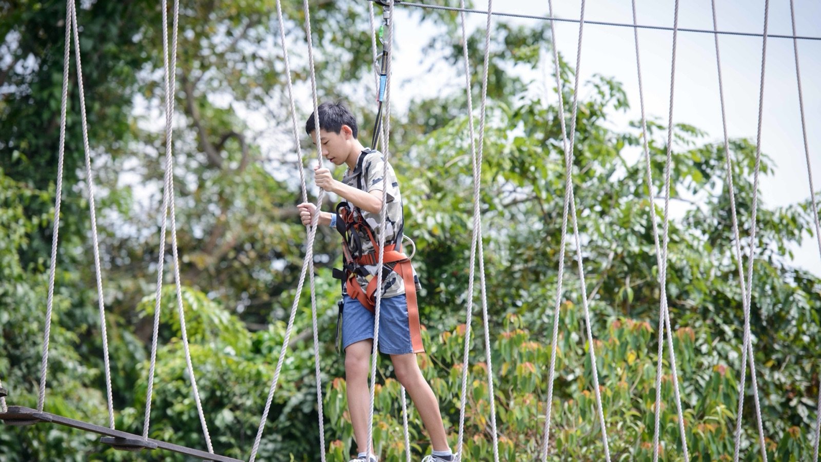 Participant fitted with safety harness and helmet by instructor